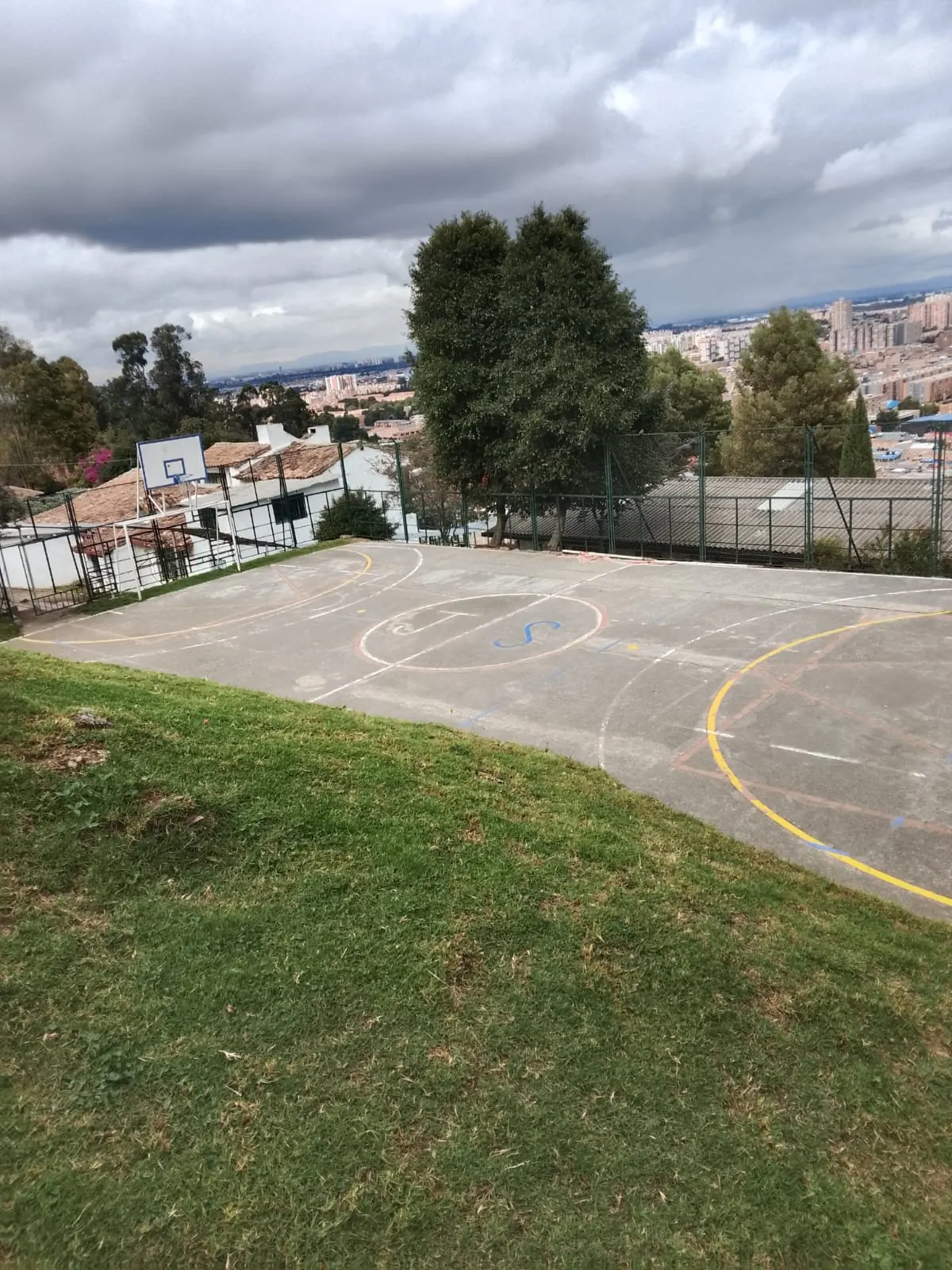 Cancha múltiple del Colegio Jonathan Swift con tablero de baloncesto y vista a Bogotá