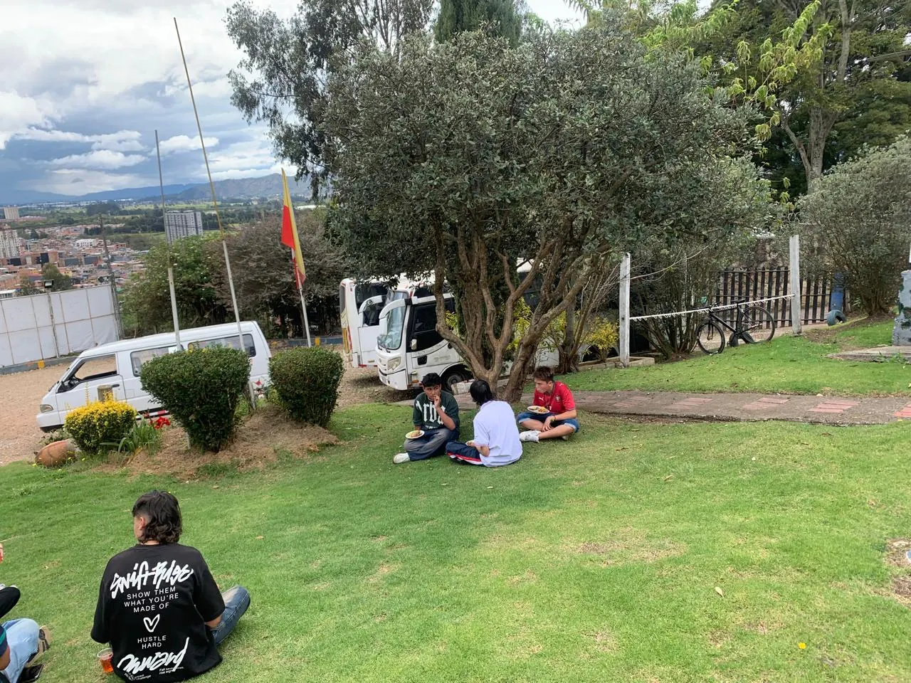 Estudiantes del colegio sentados en el césped durante una actividad al aire libre